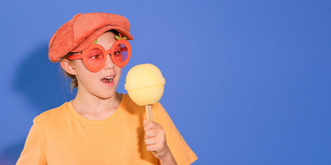 Banner with a funny girl with a giant lollipop in her hand. Copy space. Blue background