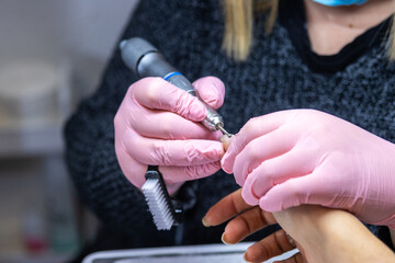 Obraz na płótnie Canvas Nail technician shaping nails in salon