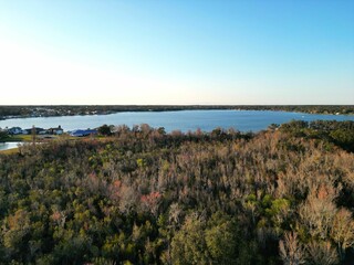 Aerial shot of a landscape and a lake under the clear blue sky