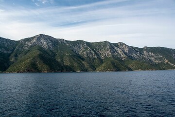 Mesmerizing view of the lake surrounded by a rocky mountainous landscape against a cloudy sky