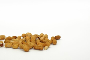 Closeup of a pile of peanuts isolated on a white background with copy space