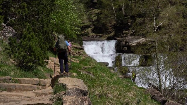 Young male hiker walking down trail in Gradas de Soaso, Ordesa natural park, Spain.