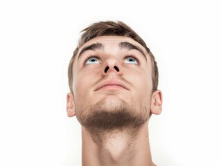 Fototapeta premium Young man looking up on white background, closeup portrait of face with eyes and eyebrows, handsome young guy, brown hair, studio shot, high resolution photography