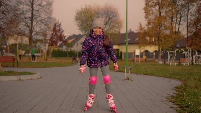Young girl is rollerblading, she stumbles and almost falls slow motion. Beautiful and healthy schoolgirl enjoying roller skating lesson