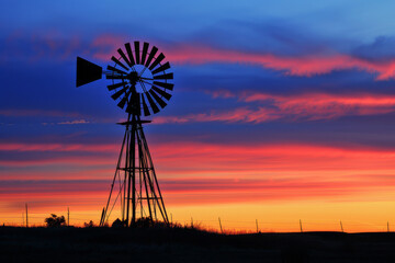 A majestic windmill against the backdrop of a vibrant sunset - Generative AI