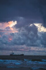 Vertical closeup shot of a large ship filled with people on the ocean on a cloudy day