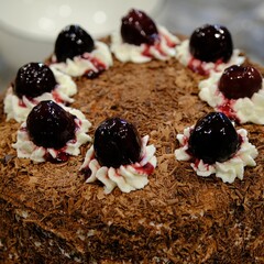 Closeup shot of a black forest cake in a restaurant decorated with cherries