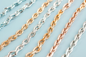 Fototapeta premium Closeup of a braided metallic chain in three different colors, golden, silver and white