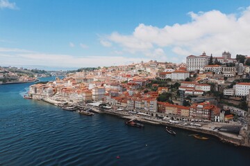 Fototapeta na wymiar Blue river Douro with the cityscape of Porto in the background on a sunny day against the blue sky