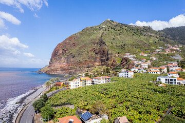 Aerial view of small farming village with banana plantation at Madeira Atlantic Ocean coast - 781982568