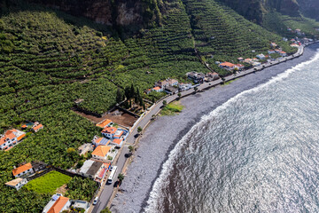 Aerial view of small farming village with banana plantation at Madeira Atlantic Ocean coast - 781983361