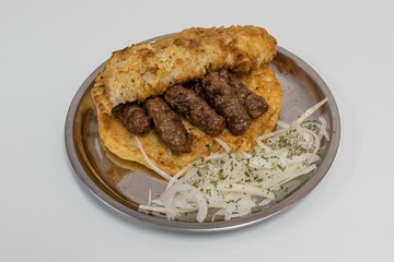 Closeup of a traditional Balkan food - delicious minced meat cevapi (cevapcici) on white background