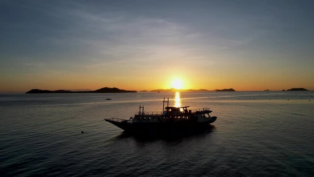 Traditional philippine boat bangka at sunset time in Linapacan, Philippines. Orange sky sunset paradise beach.