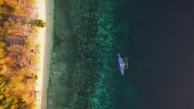 Traditional philippine boat bangka at sunset time in Linapacan, Philippines. Orange sky sunset paradise beach.