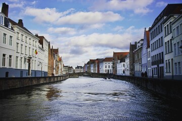 Beautiful shot of a flowing canal through historic buildings in Bruges, Belgium
