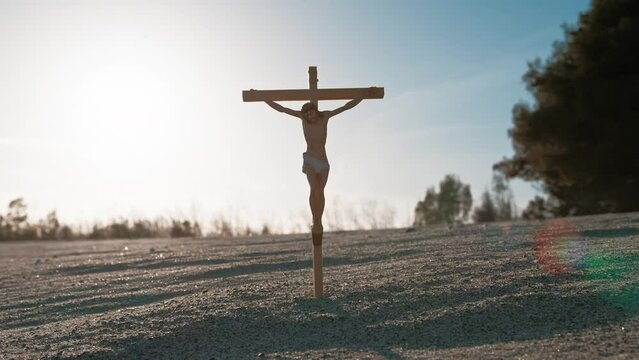 Chist Crucifix In The Sand With Sunlight