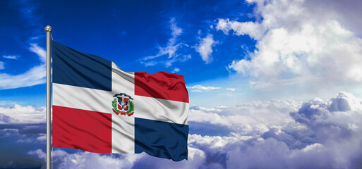 Dominican Republic national flag cloth fabric waving on beautiful Blue Sky Background.