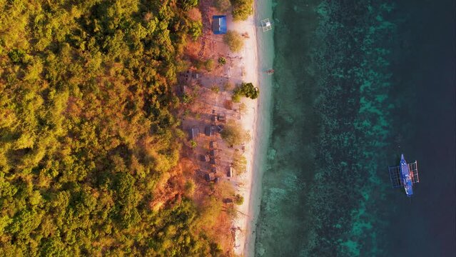 Traditional philippine boat bangka at sunset time in Linapacan, Philippines. Orange sky sunset paradise beach.
