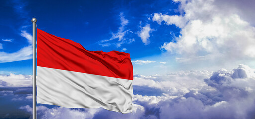 Indonesia national flag cloth fabric waving on beautiful Blue Sky Background.