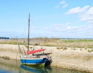 Bay of Biscay, port le Croisic city France, Older wooden sailing boat moored to the quay wall, it is low tide, support beam on the side of the hull, it prevents the boat from falling over
