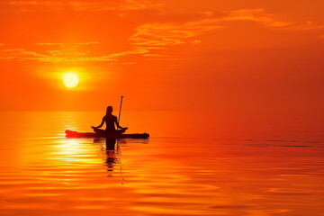 Fototapeta premium Sunrise Yoga on a Paddleboard: closeup of A lone figure practicing yoga poses on a calm lake at sunrise, silhouetted against a vibrant orange sky