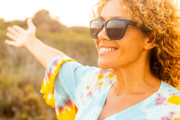 One cheerful happy woman having fun and enjoying outdoor leisure activity alone smiling and enjoying outdoor leisure activity alone wearing sunglasses for sun. People and healthy lifestyle concept