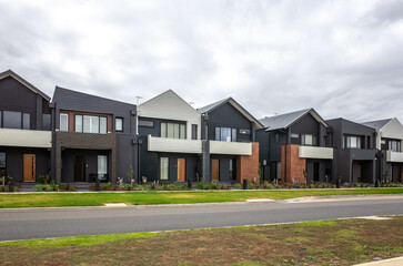 a row of modern townhouses in Australia with modern facades and contemporary design elements. Concept of suburban real estate development, property investment, housing, and living in a new suburb.