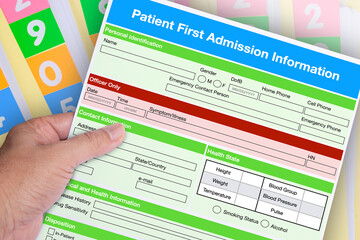 Hand holding blank patient first admission form.