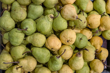 Pears Conference. Pear fruits pile on the farmer market counter. Fresh green pear texture. Top view...