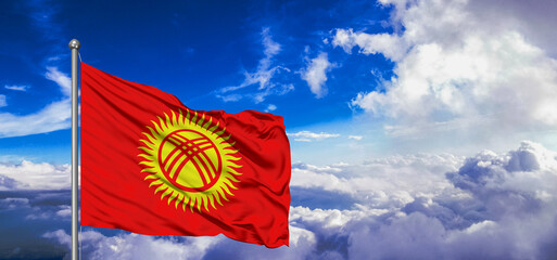 Kyrgyzstan national flag cloth fabric waving on beautiful Blue Sky Background.