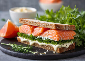 A delicious open-faced sandwich with smoked salmon, cream, and fresh greens on toasted bread, presented on a dark plate and sprinkled with seasoning. - obrazy, fototapety, plakaty
