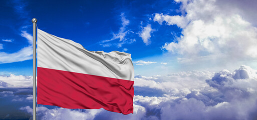 Poland national flag cloth fabric waving on beautiful Blue Sky Background.