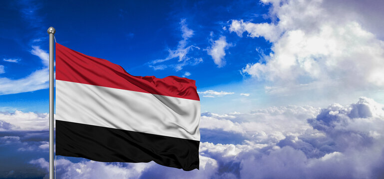 Yemen national flag cloth fabric waving on beautiful Blue Sky Background.