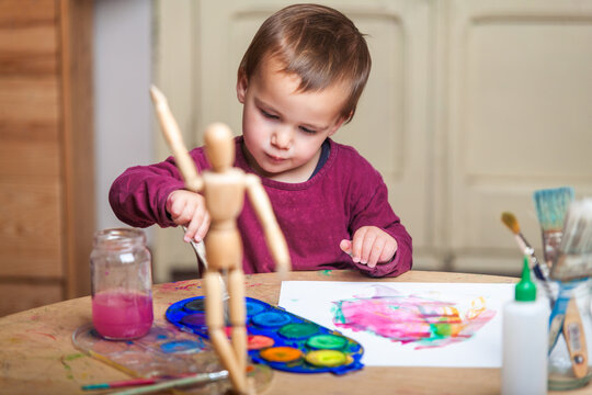 Young boy doing his creative activity of painting with watercolors at his work table. - Powered by Adobe