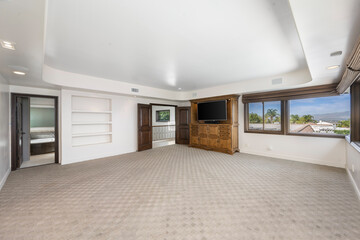Empty room with ocean view through large windows, carpeted floor in Encino, California