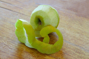 Peeled green apple on a wooden table..