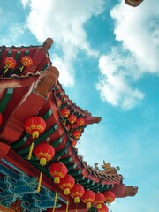 a temple with red and yellow lanterns hanging from its roof
