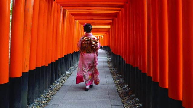 Asian women in traditional japanese kimonos visiting at Fushimi Inari Shrine in Kyoto, Japan.