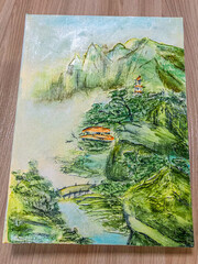 The cover of the book is in Chinese style. The painting is in the style of an old color image.