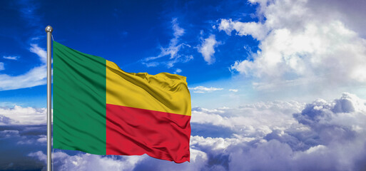 Benin national flag cloth fabric waving on beautiful Blue Sky Background.