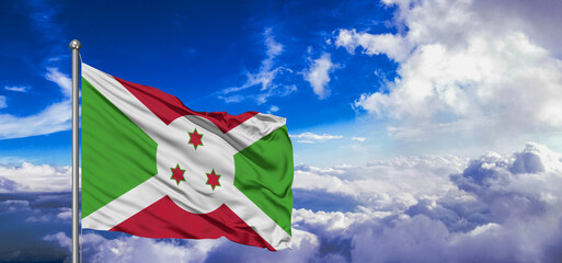 Burundi national flag cloth fabric waving on beautiful Blue Sky Background.