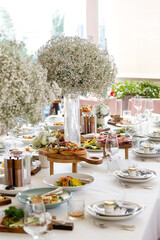 Served wedding table with decorative fresh white gypsophila flowers. Celebration details. Flower...