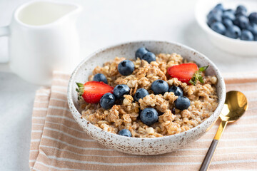Multigrain porridge bowl with blueberries, strawberries for healthy vegan breakfast. Clean eating concept. Closeup view - 782023117