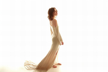 Elegant Woman in Flowing Dress Captured in Sunlit Studio Banner