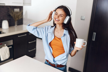 Young woman enjoying her morning routine with favorite music and coffee, holding cup in hand,...