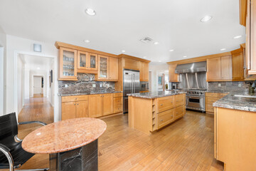Kitchen with stainless appliances and counters on wooden floor in Encino, CA