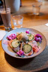 torched salmon with pink cauliflower, cucumber, radish and poached egg topped with furikake and Japanese mayo