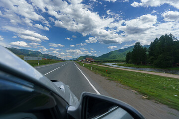 feelings of speed due to smeared roadsides and nature when driving fast on a highway with a blue sky