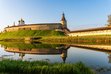 Pskov, Russia, September 11, 2023. Reflection of the walls of the old fortress in the water of the river. - obrazy, fototapety, plakaty