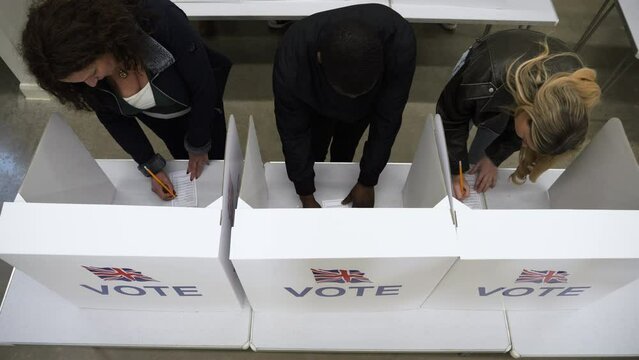 4K: Group of Voters voting at Polling Place for the UK Election.  People Stood at booths. Looking down from above. Stock Video Clip Footage